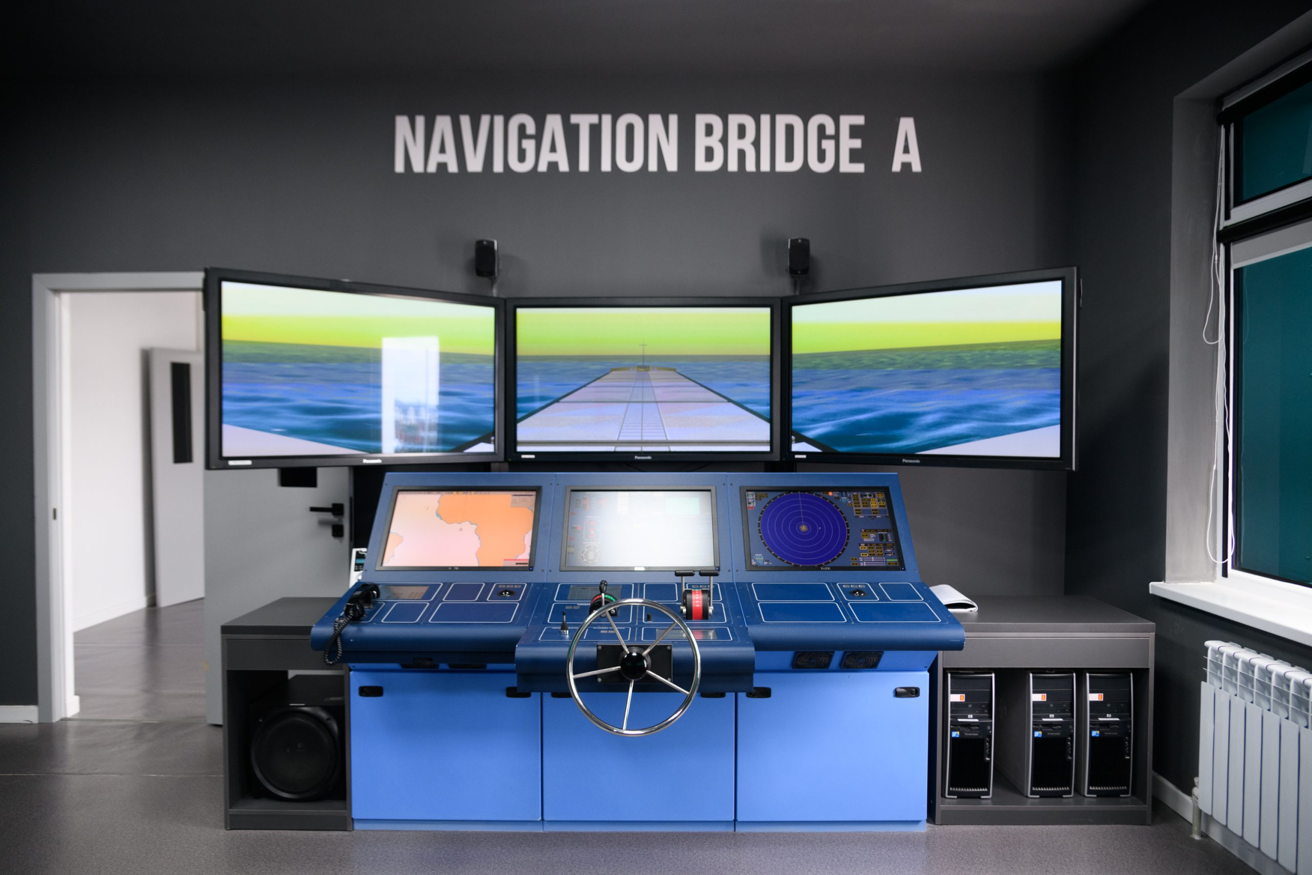 Navigation bridge simulator: helm, radar, chart plotter and three screens simulating the sea
